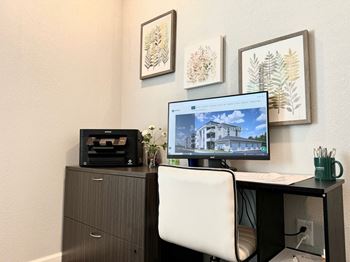 a desk with a computer and a printer on it